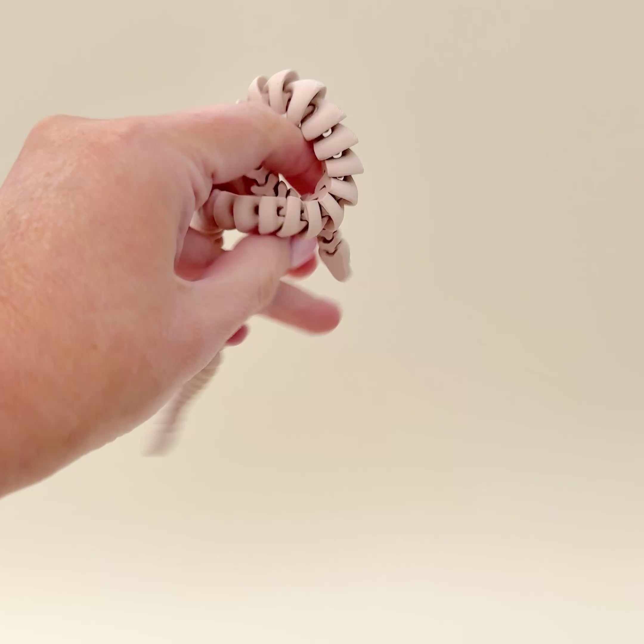 The fidget snake showing its smooth articulation and flexible movement for sensory play.