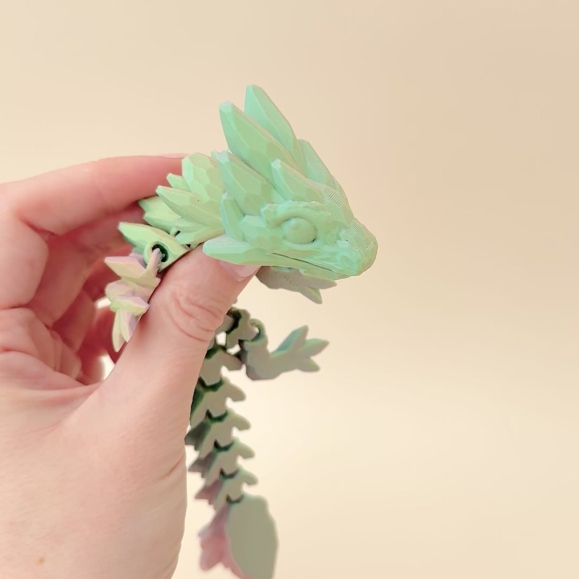 Articulated 18cm dragon fidget toy with dynamic colour-changing filament, ideal for sensory play and collectors.