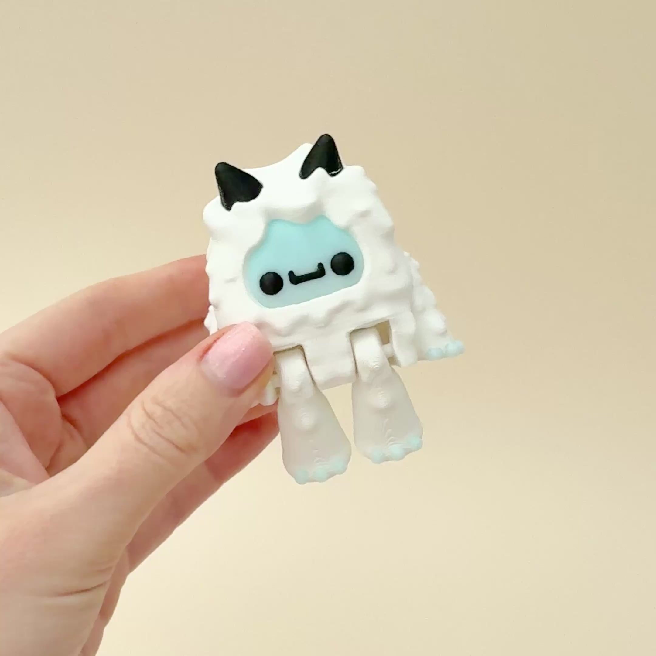 White Yeti fidget toy with movable arms and feet, frosty blue accents, and a chunky design.