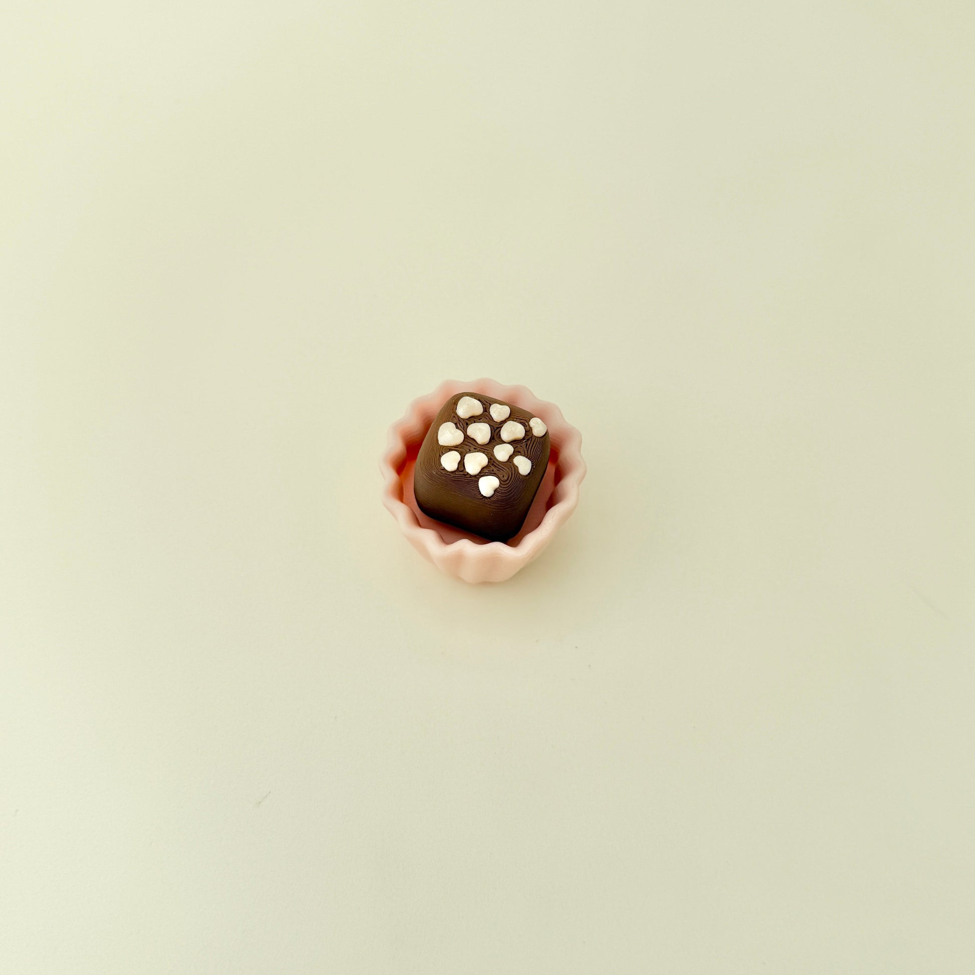 a discreet handheld fidget with tactile sprinkles and a ridged wrapper surface
